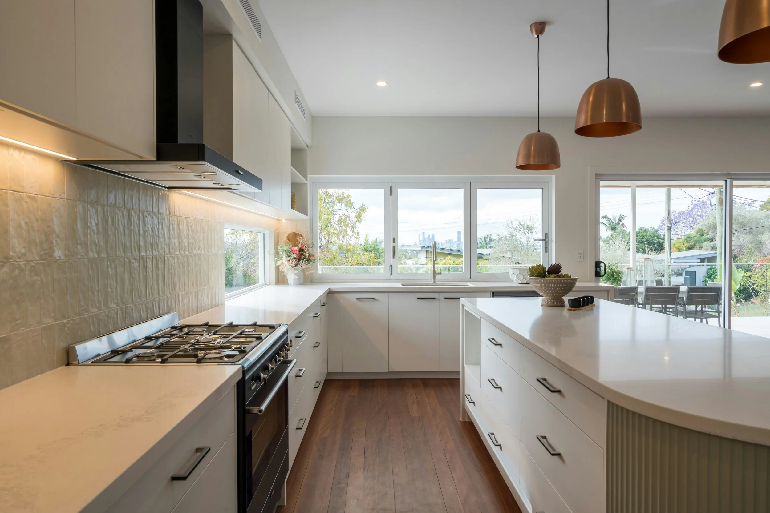Modern kitchen with white island and copper pendant lights